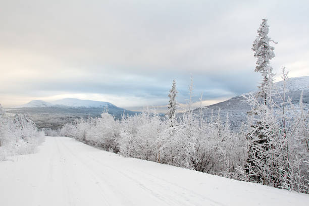 Snowy road to far mountains stock photo