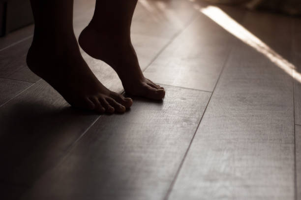 istock Woman's legs on a warm wooden floor 910499468