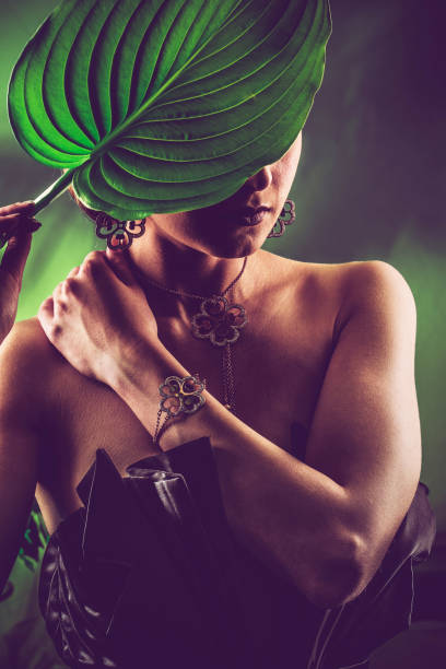 istock Mysterious Woman Hiding Behind a Big Green Leaf 910506706