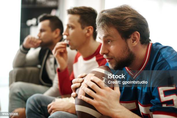 Focused Watching Football Game At Home Stock Photo - Download Image Now - American Football - Sport, American Football - Ball, Watching