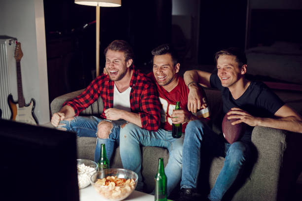 istock Men watching american football competition 910510280