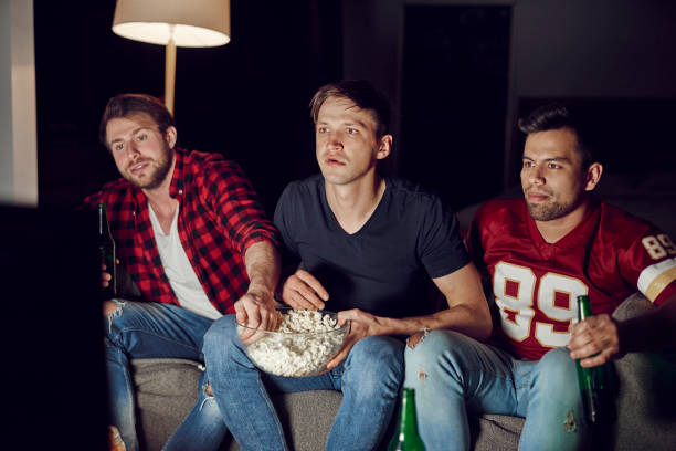 istock Focused men watching footaball match in the evening 910511326