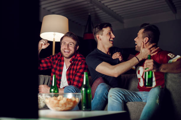 istock Ecstatic football fans cheering at home 910511950