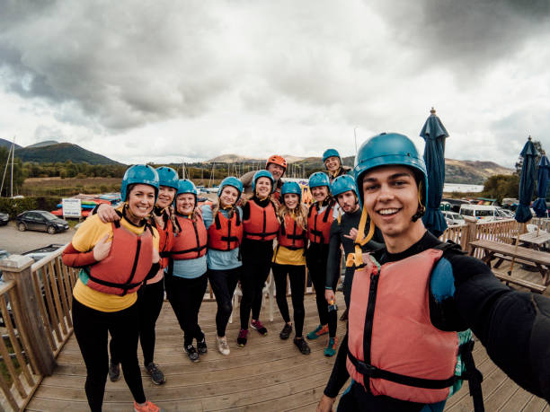 Wetsuit Selfie A group takes a selfie prior to a rafting experience paddleboard surfing oar water sport stock pictures, royalty-free photos & images