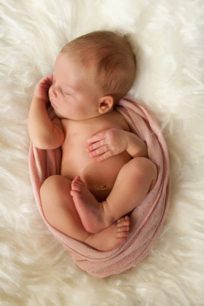 Sleeping newborn girl Newborn girl sleeping in a cocoon of scarf home birth photos stock pictures, royalty-free photos & images