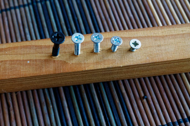 istock Scattered screws screwed into the wooden plank 910520470