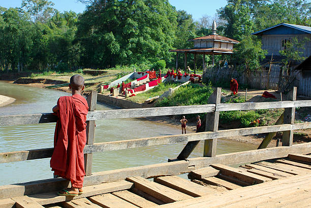 jeune moine sur le pont de bois - hinduism monk buddhism myanmar photos et images de collection