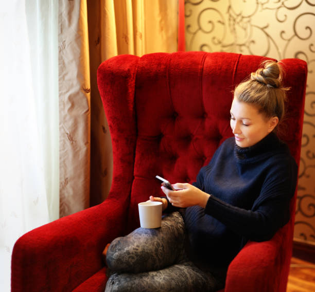 istock Woman sitting in a chair and using smart phone. 910523588
