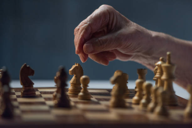 istock Close-up view of senior man playing chess board game 910523736