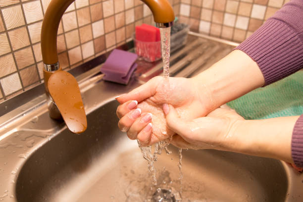 istock A girl washes her hands under the tap 910523808