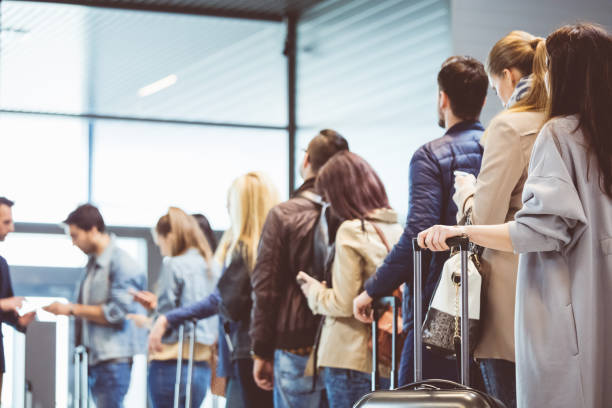 Group of people standing in queue at boarding gate Shot of queue of passengers waiting at boarding gate at airport. Group of people standing in queue to board airplane. airport terminal stock pictures, royalty-free photos & images