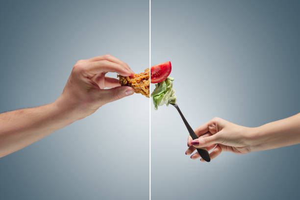 Male hand holding roasted chicken drumstick at studio