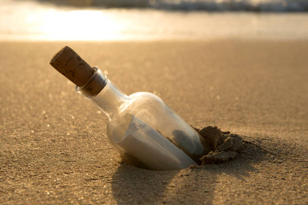istock Message in a Bottle Half-Buried in Sand 910524222