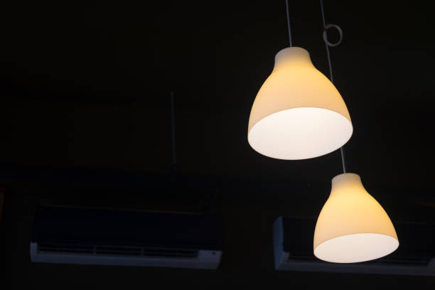 istock Two light bulb lamp hanging in dark room 910524610