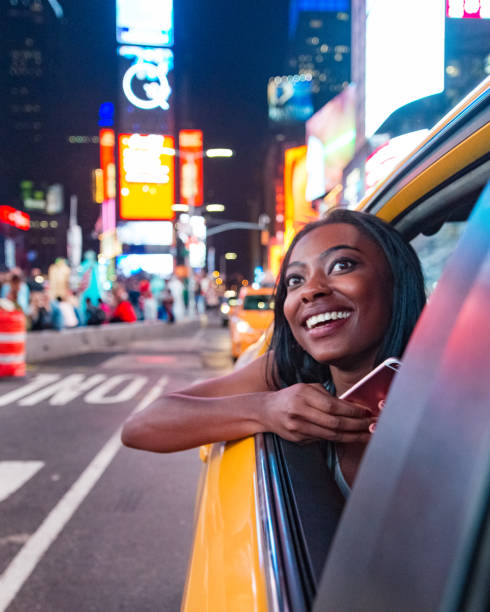 Taxi Ride in New York City African American Woman Visiting New York in a Yellow Taxi taxi photos stock pictures, royalty-free photos & images