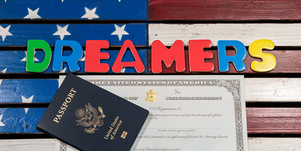 Dreamers concept on wooden USA flag with passport and naturalization certificate