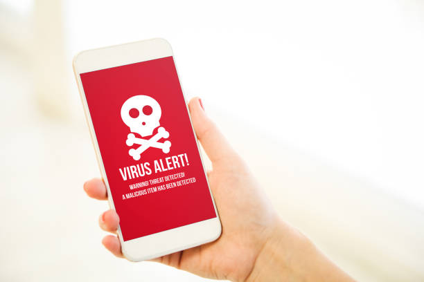istock Woman holding a pink gold blank smartphone virus alert 910535748
