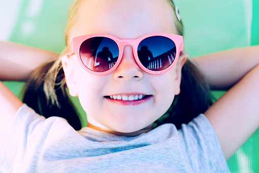 Close-up Of A Young Happy Little Girl Lying In Hammock