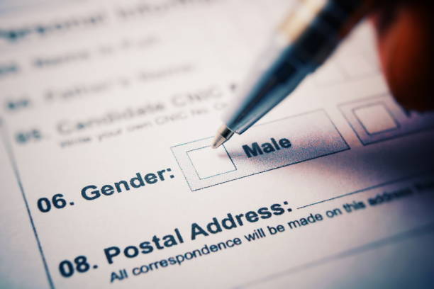 istock Application form - check male or female. Pen in hand 910543098