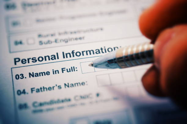 istock NAME IN FULL on a printed form close up. pen in hand writes 910543248