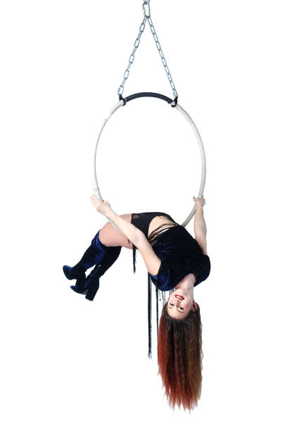 istock Aerial acrobat in a hoop. Young woman performs the acrobatic elements in air ring. Studio shooting, isolated on white background. 910546708
