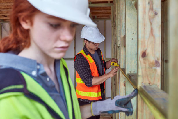 istock Colleagues measuring frame with tape at site 910547150