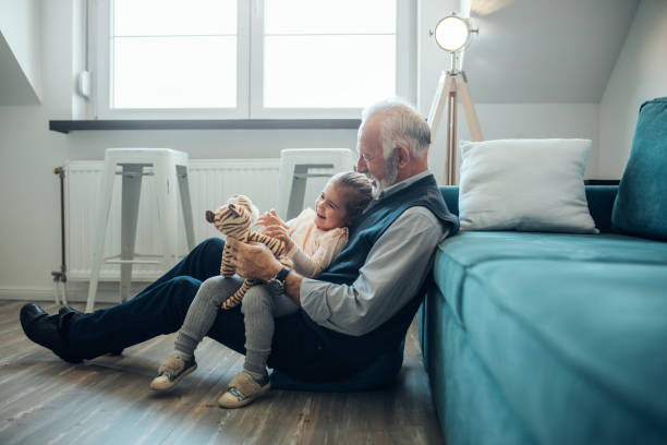 彼女はおじいちゃんのジョークを楽しんでいます - grandfather ストックフォトと画像