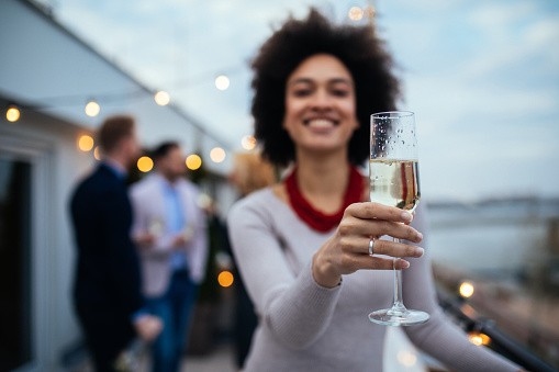 Shot of a young happy woman holding a champagne flute