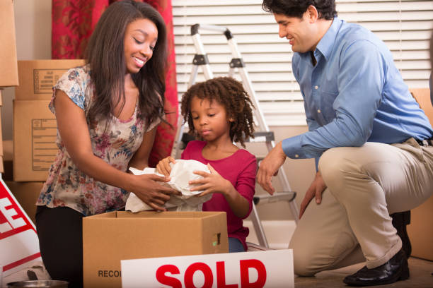 istock Multi-ethnic family packs, unpacks moving boxes in new home. 910561042
