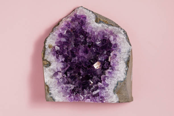 istock The amethyst stone on pastel pink background. Minimalism flat lay style. 910563244