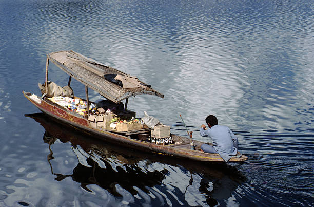 Shikara shop on the lake at Srinagar Salesmen sell provisions from their shikaras to the occupants of the houseboats on the lakes in Srinagar, Kashmir. lake nagin stock pictures, royalty-free photos & images