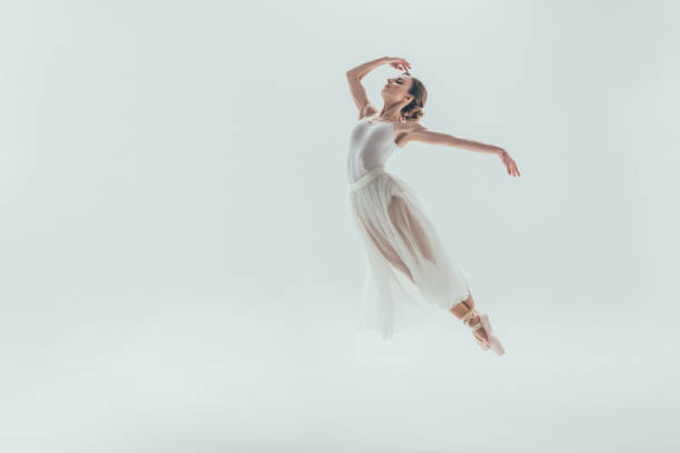 istock elegant ballet dancer in white dress jumping in studio 910577934