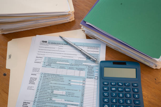 istock IRS Tax Form with Folders, Calculator and Pen 910578156