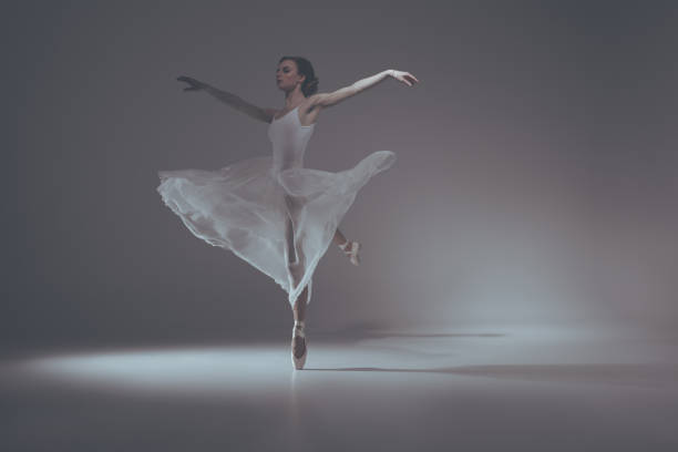 istock elegant ballet dancer dancing in white dress 910578248