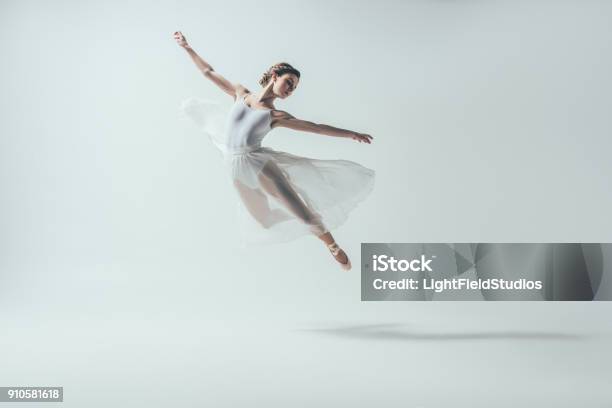 Photo libre de droit de Danseur De Ballet Élégante En Robe Blanche Sautant En Studio banque d'images et plus d'images libres de droit de Danser