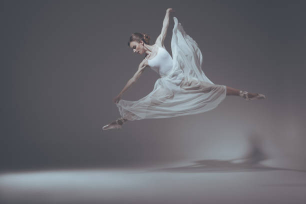 istock beautiful ballet dancer jumping in white dress 910581840