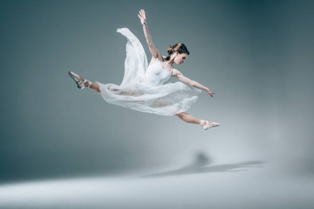 istock elegant ballet dancer jumping in white dress 910582324