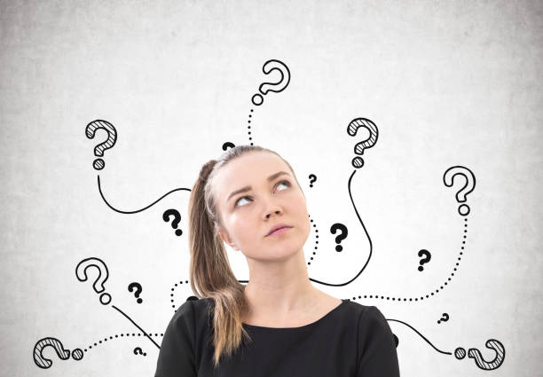 istock Pensive woman with a ponytail, question marks 910585944