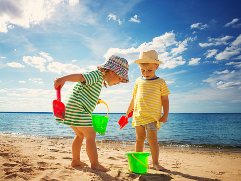 Boy and girl playing on the beach on summer holidays