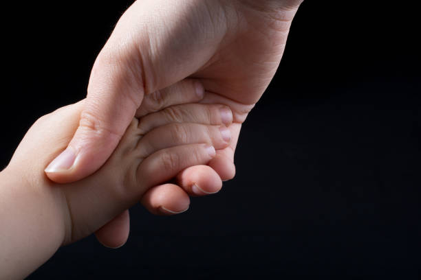 istock Adult and child hold hands 910606884