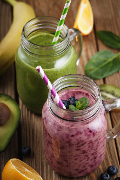 istock Fruit smoothies in glass jars on a wooden table 910609520