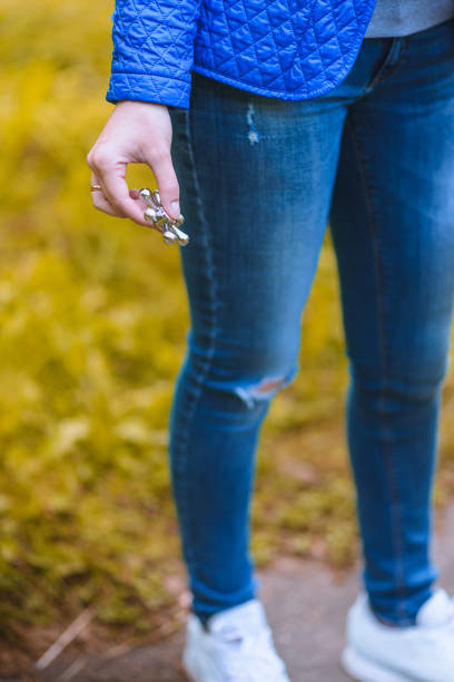 istock Girl playing with a Tri Fidget Hand Spinner outdoors in the park 910609810