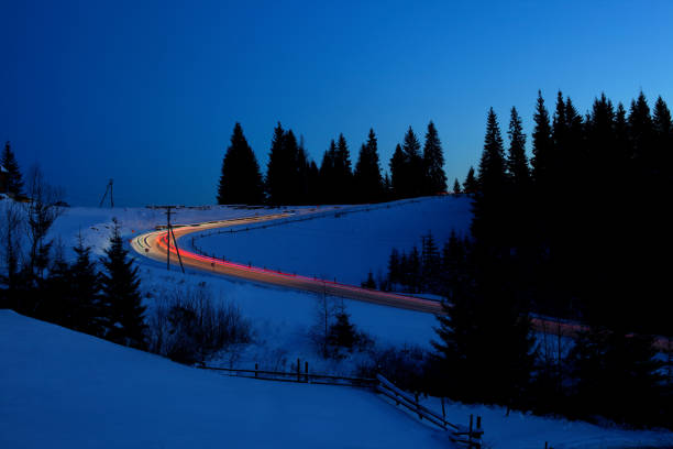 istock Car lights on winter snowy road 910619254