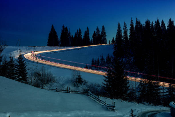 istock Car lights on winter snowy road 910619260