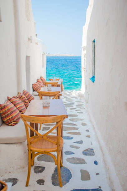 panchine con cuscini in un tipico caffè greco all'aperto a mykonos con splendida vista sul mare sulle isole cicladi - paros foto e immagini stock