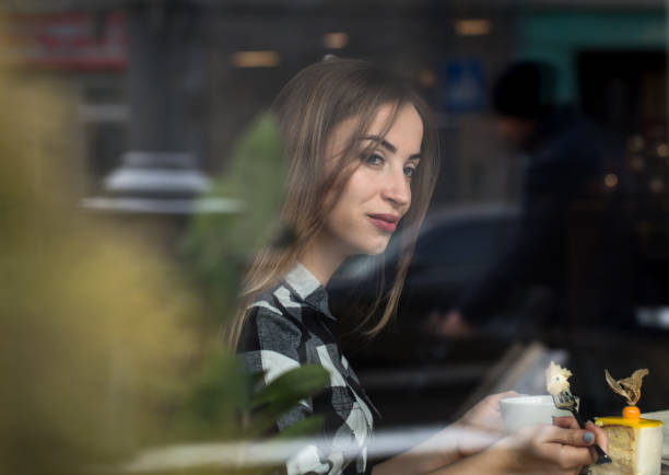Beautiful girl reads a book in a cafe