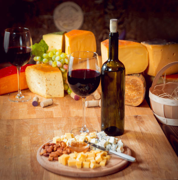 сыр и вино на темном столе. - fetta cheese стоковые фото и изображения