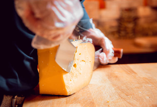 нарезать ножом кусочек сыра - fetta cheese стоковые фото и изображения
