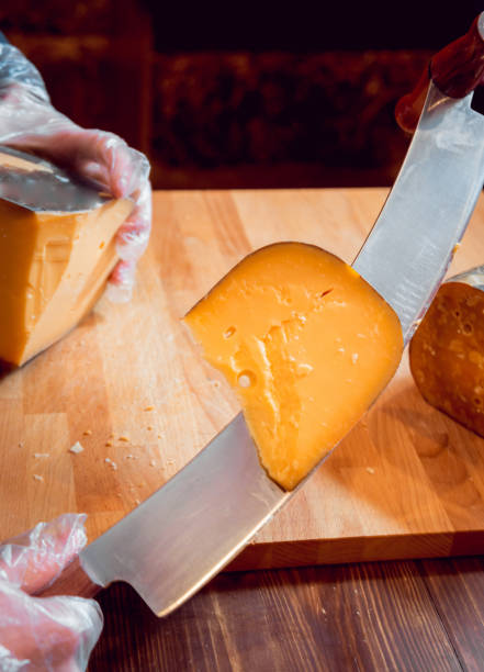 нарезать ножом кусочек сыра - fetta cheese стоковые фото и изображения