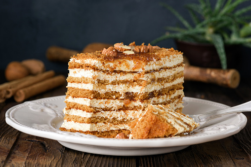 Honey cake with almonds on white plate. Russian cake Medovik